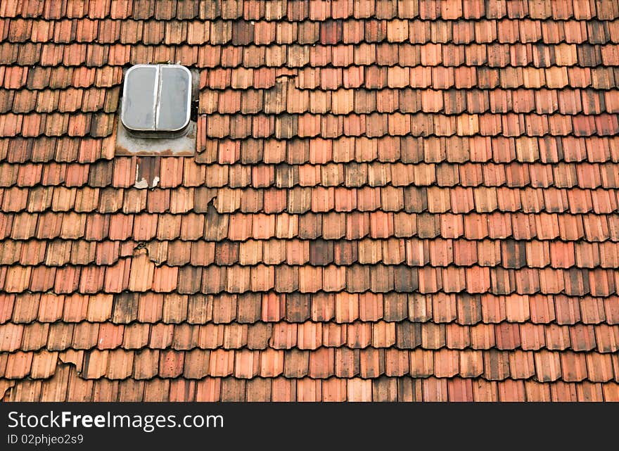 An old roof with a skylight needs renovation. An old roof with a skylight needs renovation