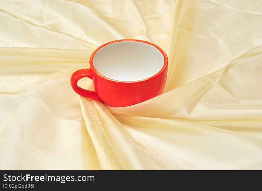 Photo of single red cup at the golden fabric drapery