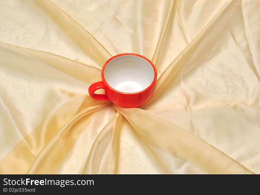 Photo of single red cup at the golden fabric drapery