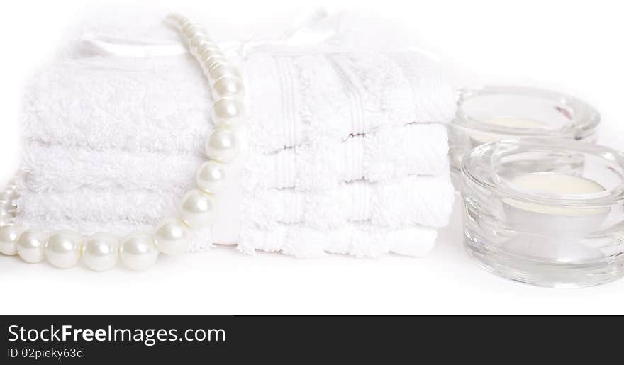 Spa towels and candles on white background