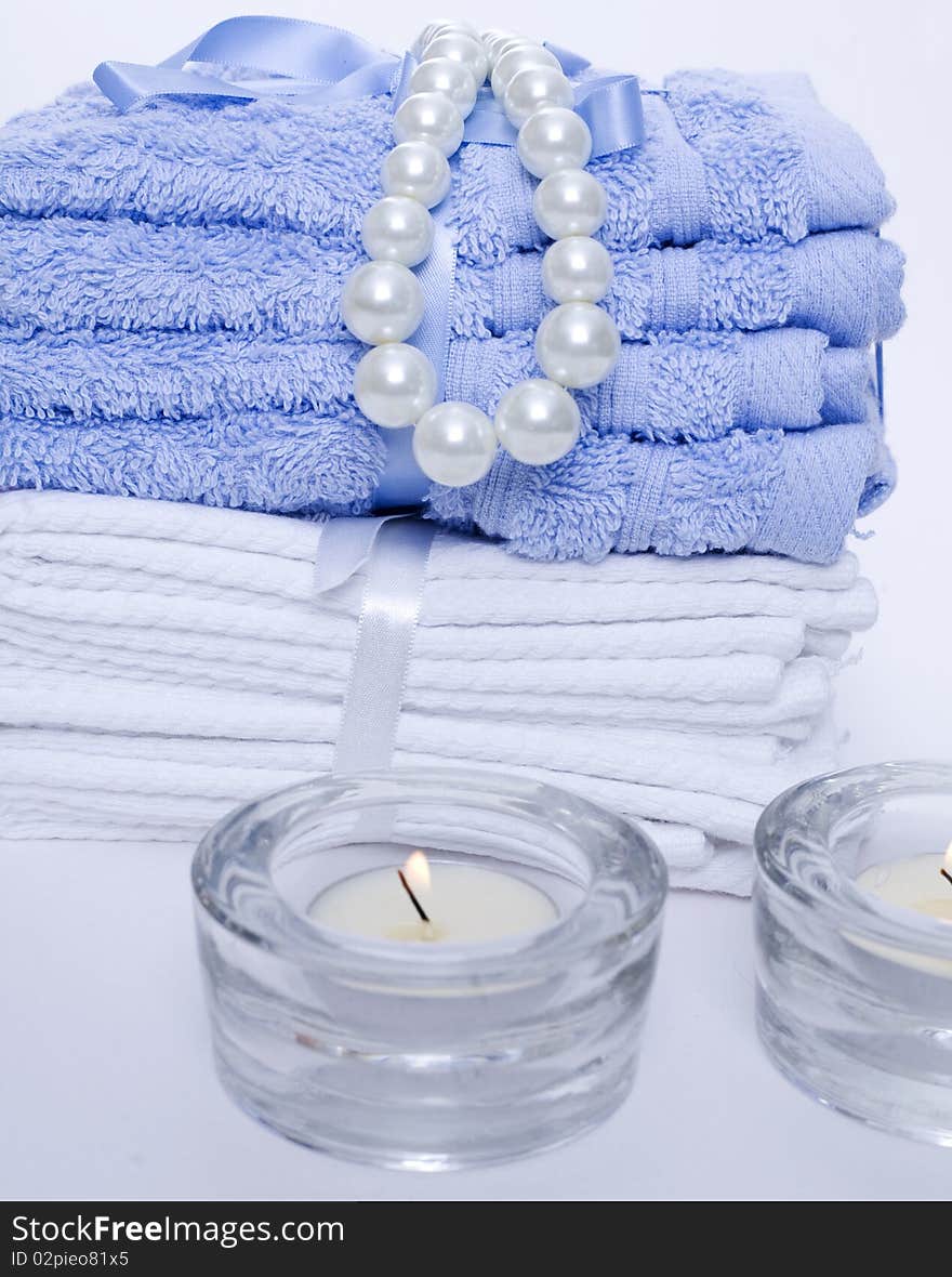 Spa towels and candles on blue background