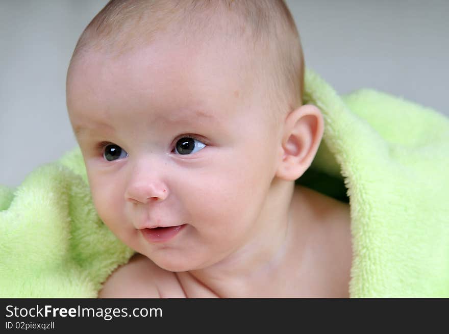 Cute little baby under green blanket