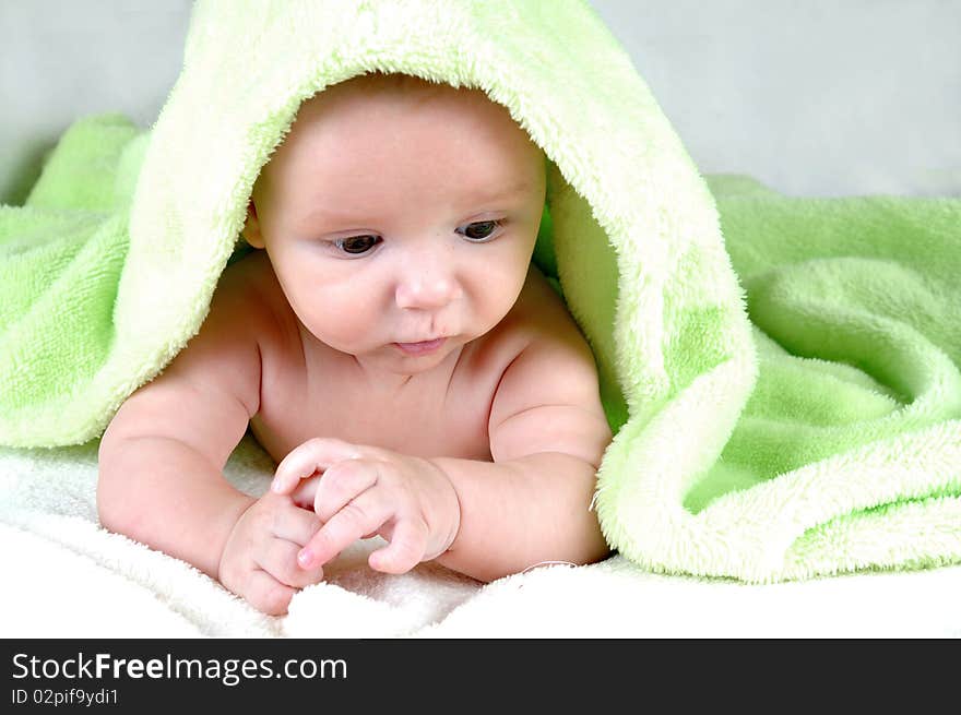 Cute little baby under green blanket