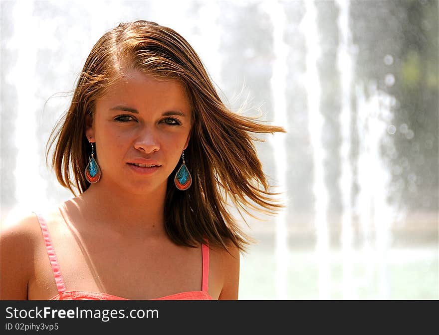 Teen girl standing by a fountain.