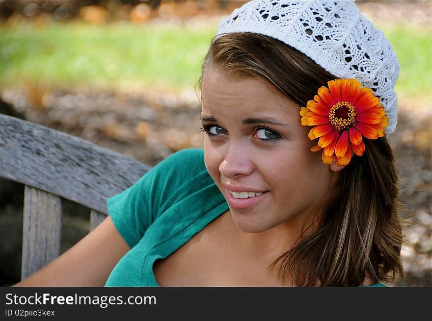 Teen girl relaxing on a park bench.