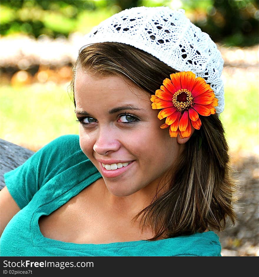 Teen girl relaxing on a  park bench.