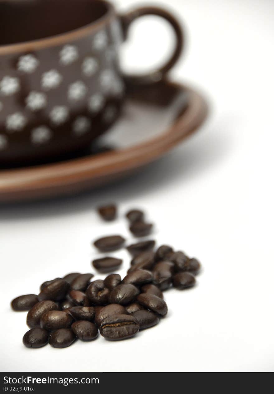 Shallow focus on coffee beans with cup and saucer. Shallow focus on coffee beans with cup and saucer