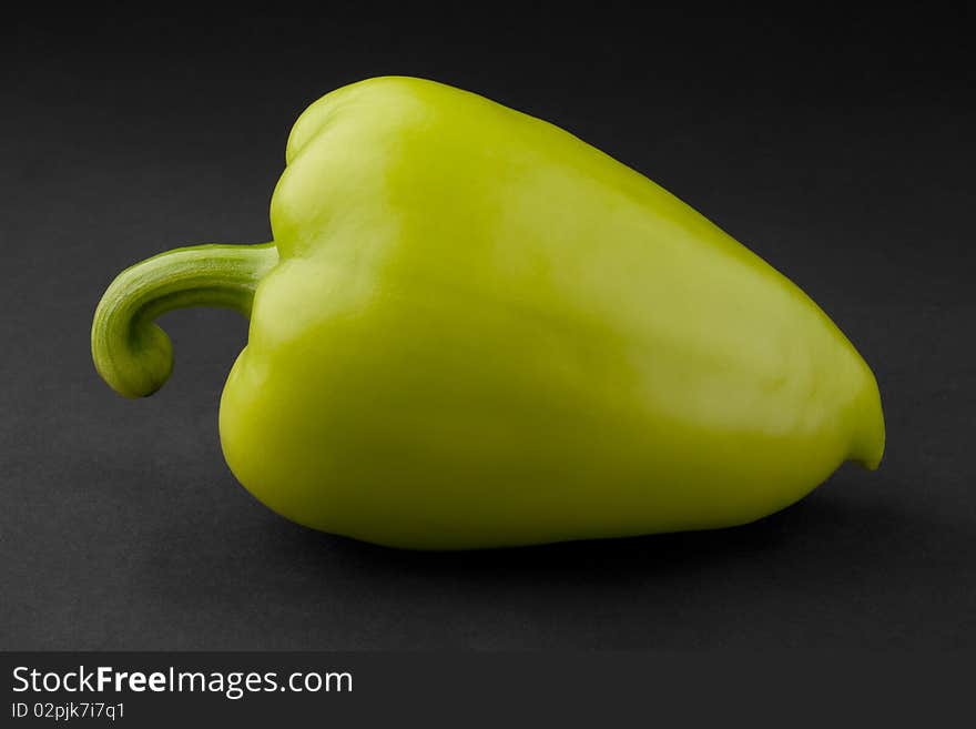 Green bell pepper on a black background