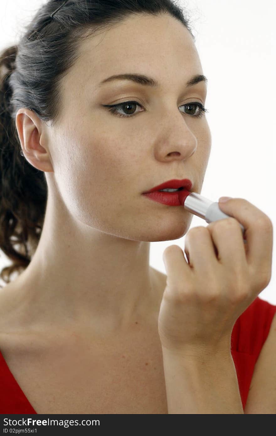 Girl putting on some red lipstick. Girl putting on some red lipstick