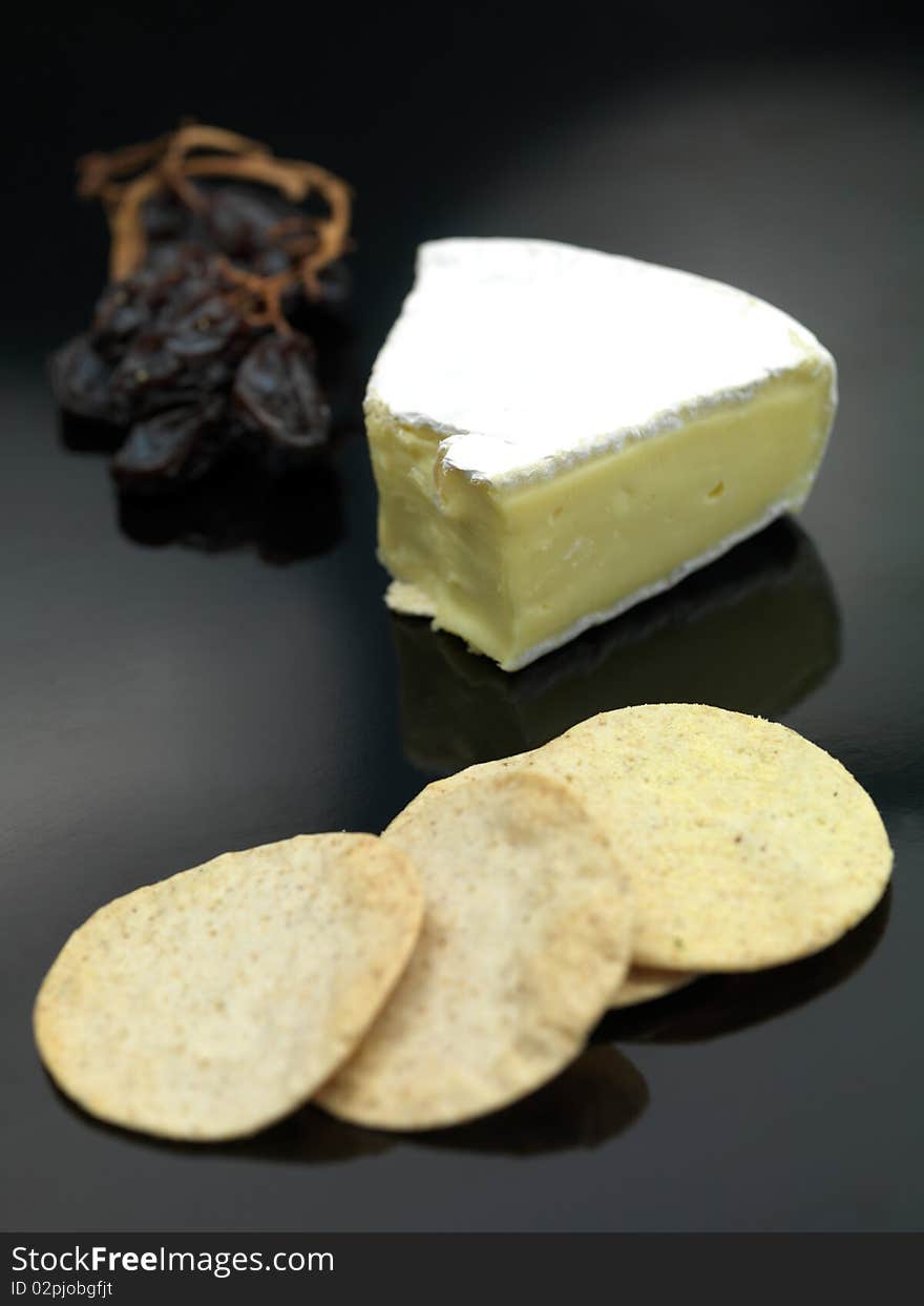 Brie cheese isolated on against a black background