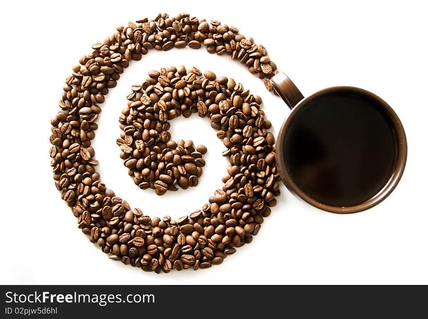 Coffee grains lying in the shape of a swirl with the cup. Coffee grains lying in the shape of a swirl with the cup