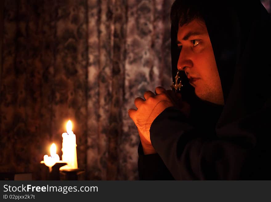 A man praying on a dark background