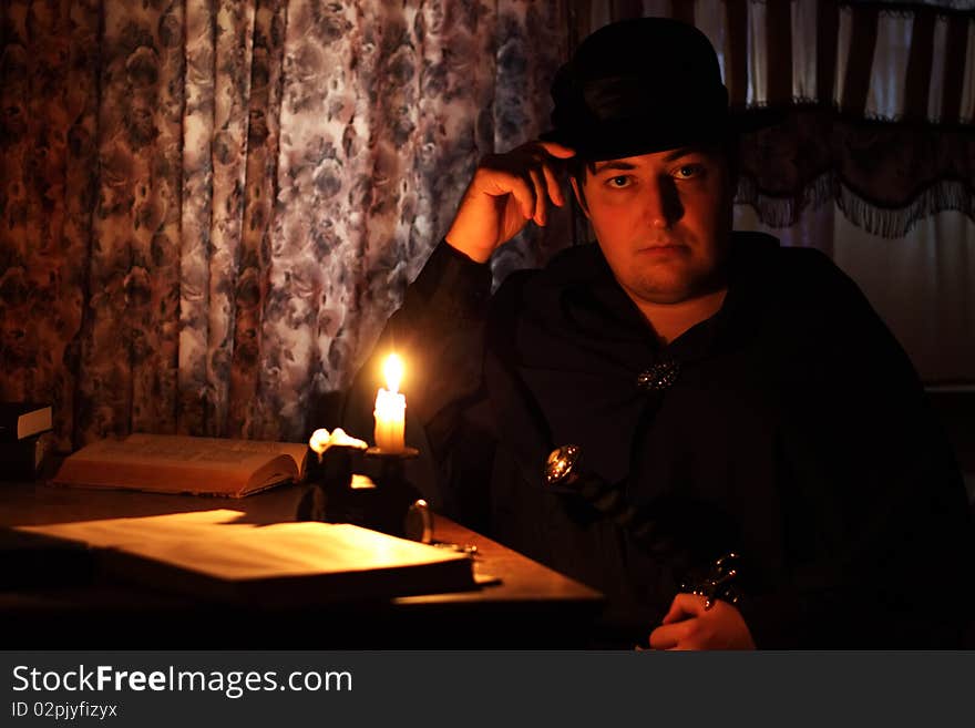 Man sitting by candlelight on a dark background