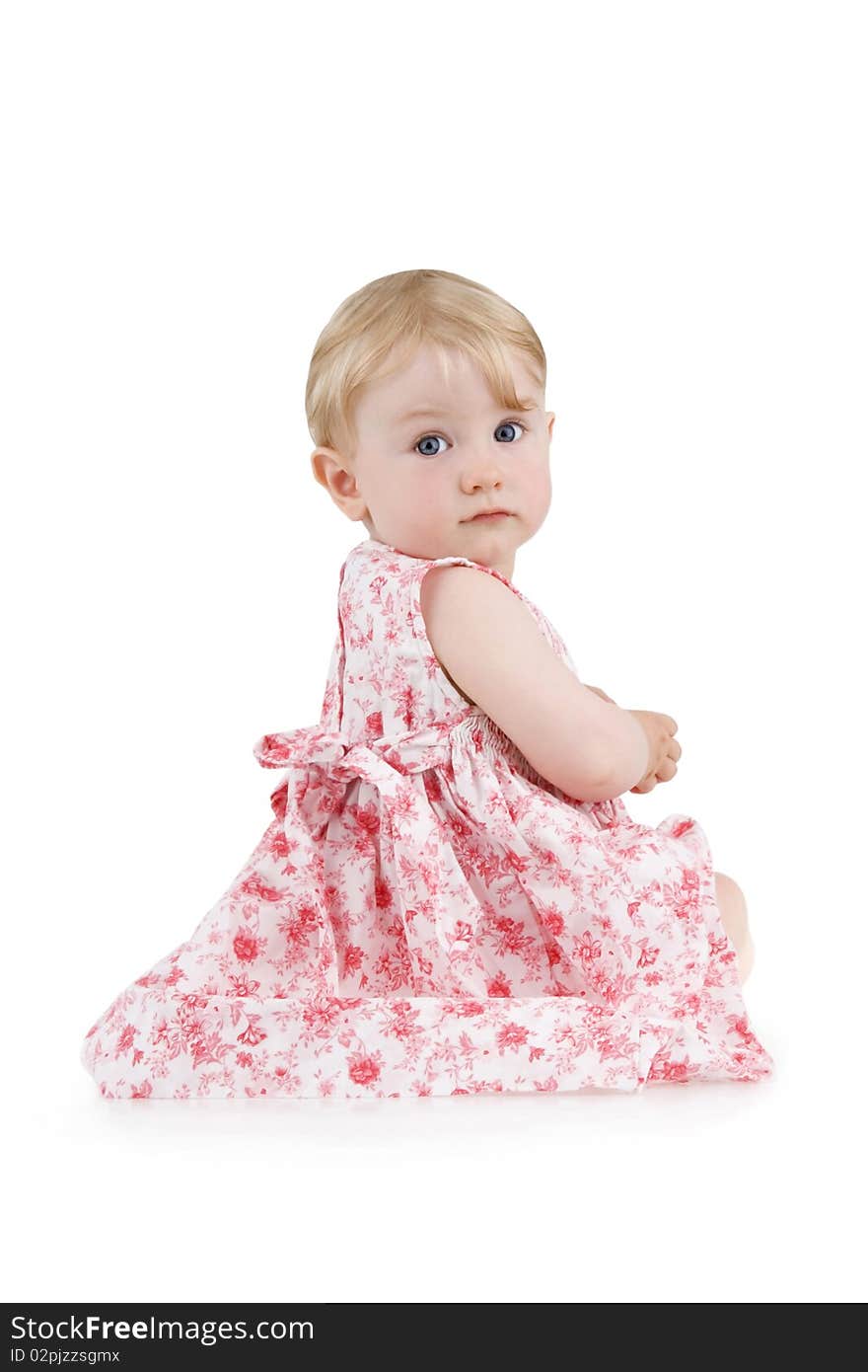 Beautiful little girl sits in flowered dress on white background.