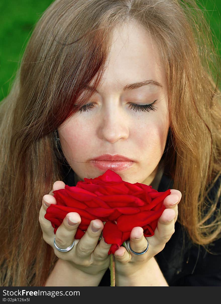 Young woman smelling red rose. Young woman smelling red rose