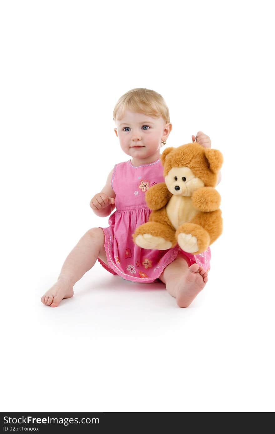 Toddler sits his toy in rosy dress on white background.