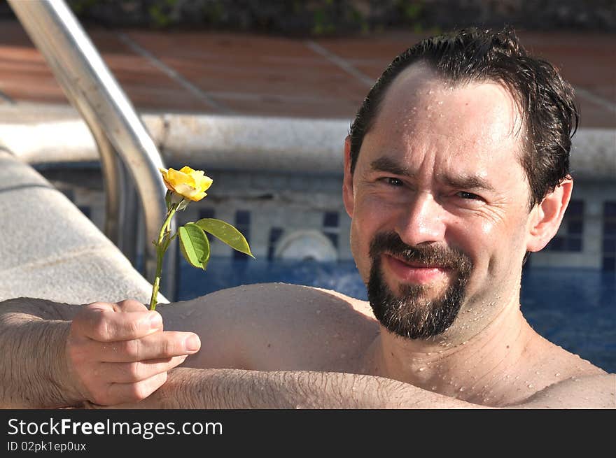 A middle age man is holding a yellow rose. A middle age man is holding a yellow rose.