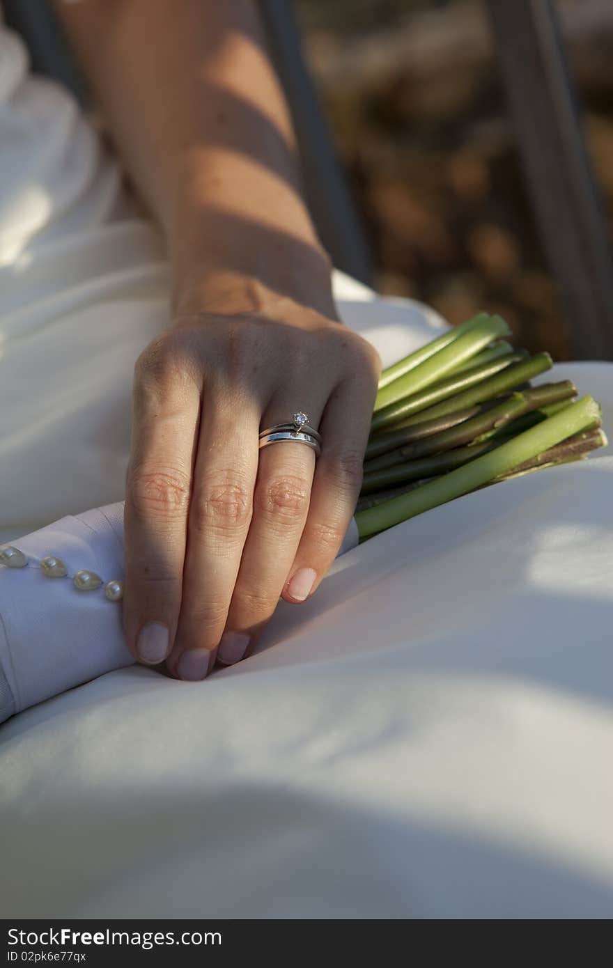 Close-up of the bride dress and arm with a nice bouquet. Close-up of the bride dress and arm with a nice bouquet