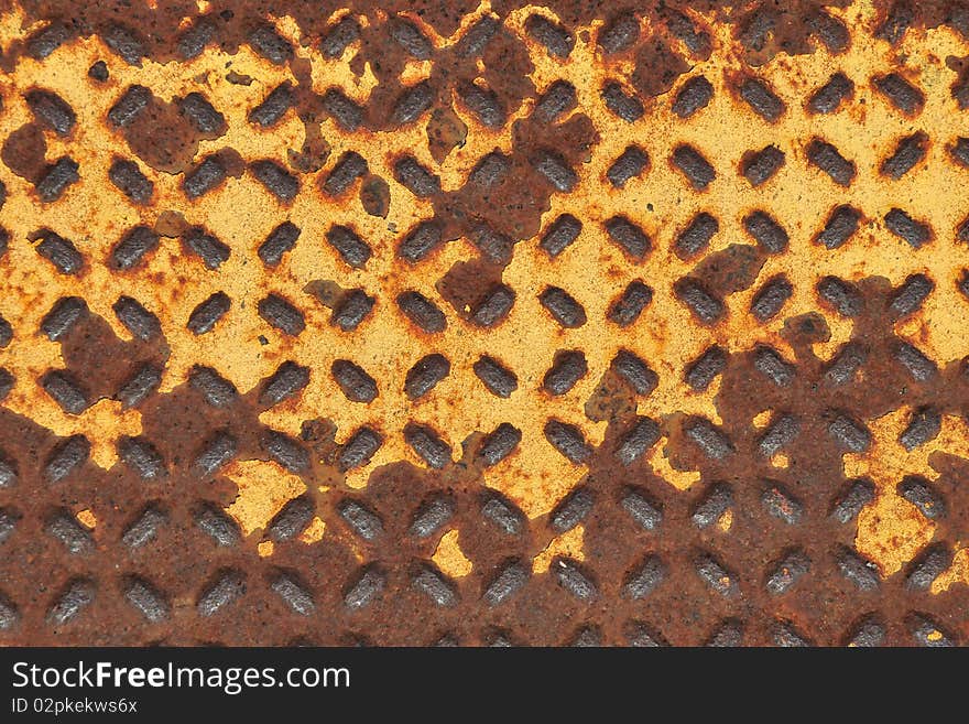 A rusty and yellow grate for walking to and from a place. A rusty and yellow grate for walking to and from a place.