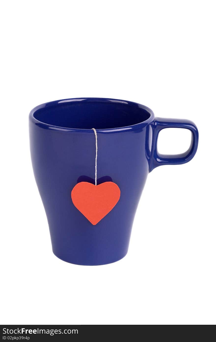 Tea bag with red heart-shaped label in blue cup