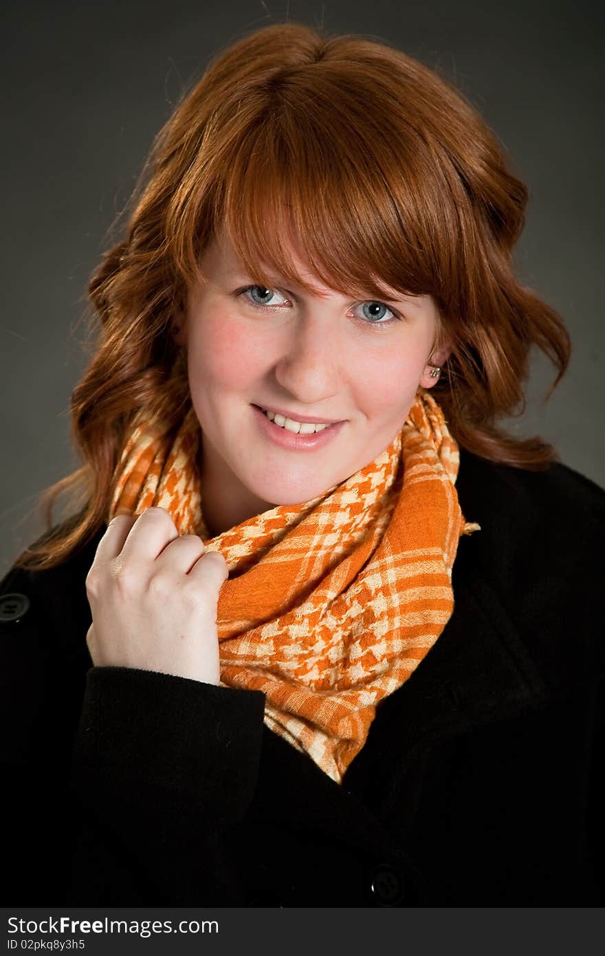 Beautiful teen girl with scarf in front of dark green background