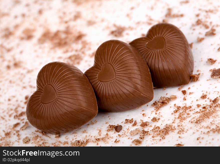 Three chocolate hearts on white background