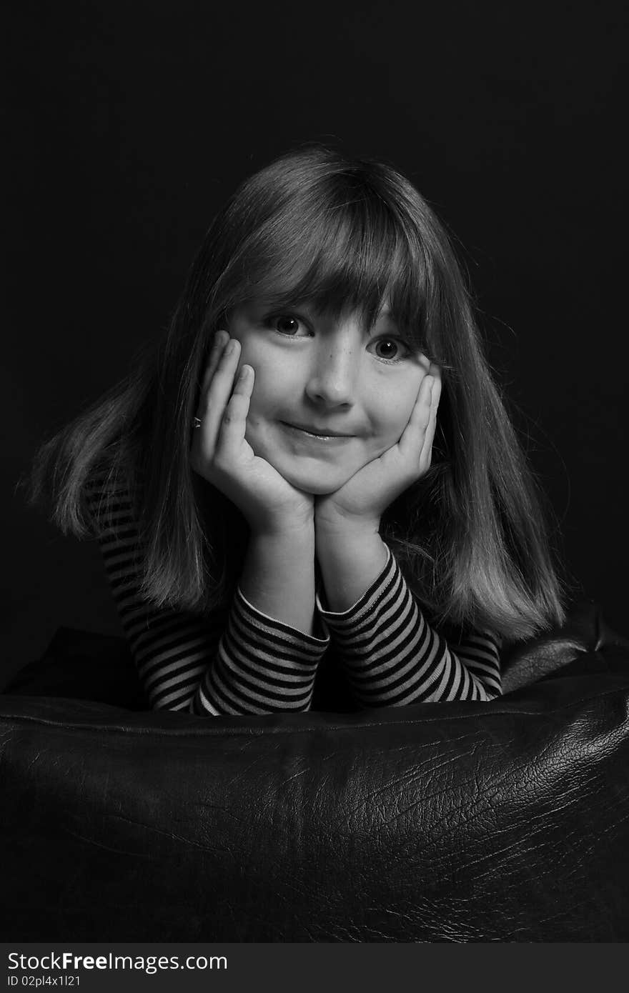 Young girl in stripey top leans on cushion looking into camera. Young girl in stripey top leans on cushion looking into camera.