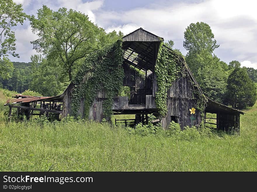 Old barn with a large yellow flower added to it. Old barn with a large yellow flower added to it.