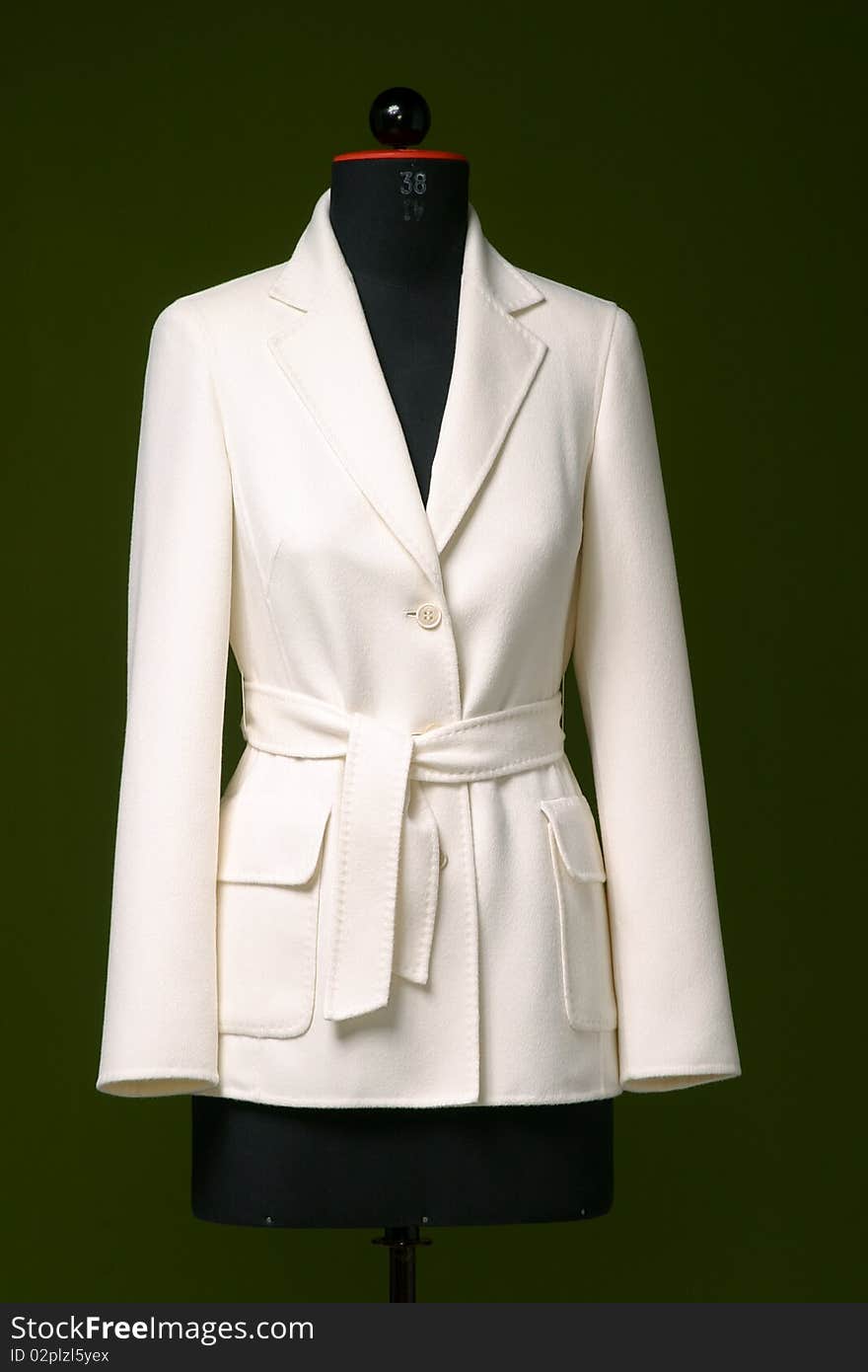 Studiophoto of a tailor mannequin in front of a green background.