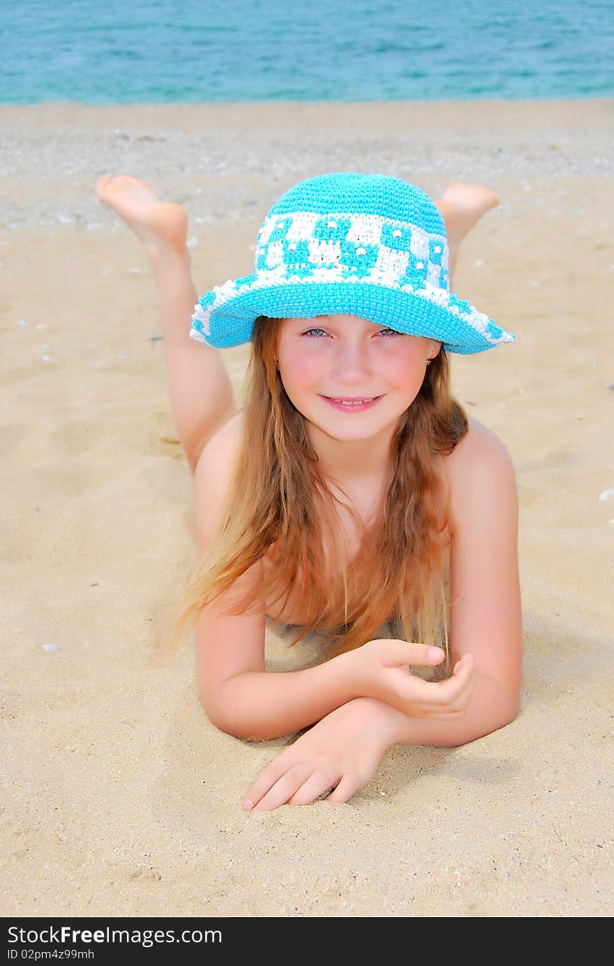 The little girl in hat on the beach. The little girl in hat on the beach