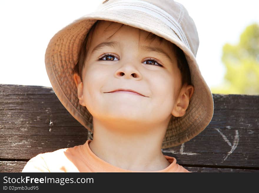 Portrait of pleased smiling little boy in hat, outdoor shot. Portrait of pleased smiling little boy in hat, outdoor shot