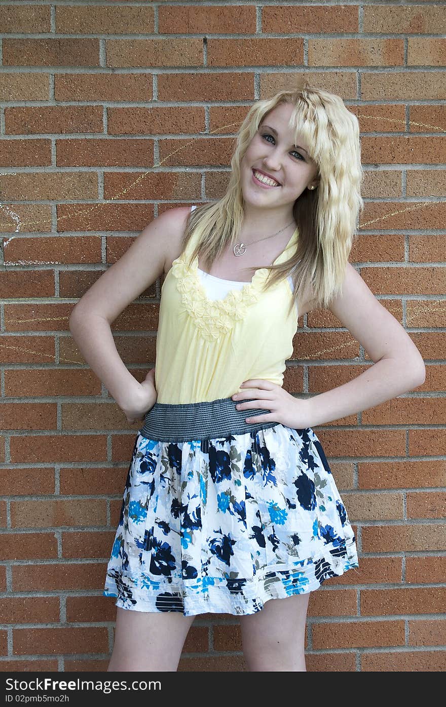 Girl standing next to brick wall