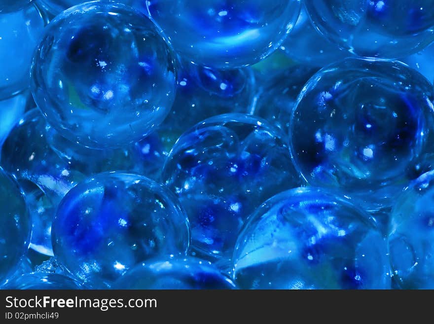 Close up of bright blue marbles with reflections of light