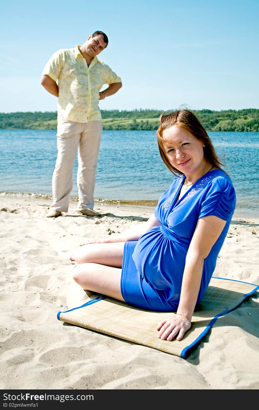 Young married couple taking a rest on the river shore