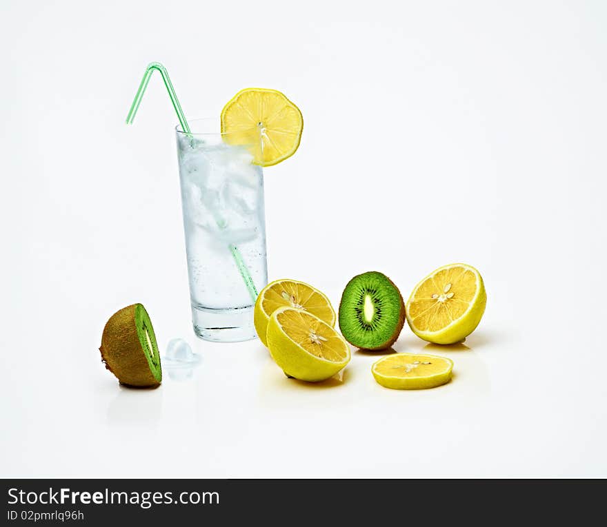 A glass of iced lemonade or water,sliced lemons and kiwi