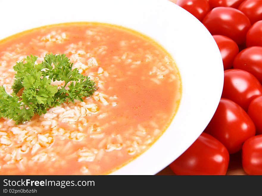 Tomato soup with rice decorated with parsley with fresh tomatoes