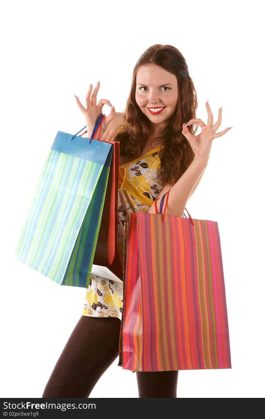 Beautiful shopping girl with bags indicating OK sign (isolated on white background)