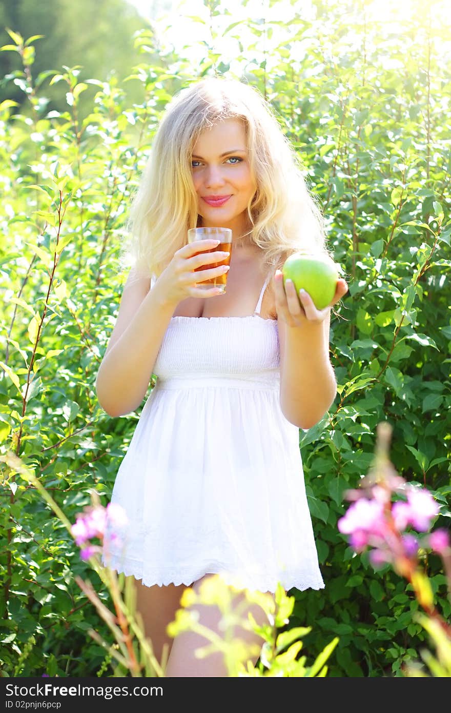 Beautiful girl is holding an apple and juice. Beautiful girl is holding an apple and juice