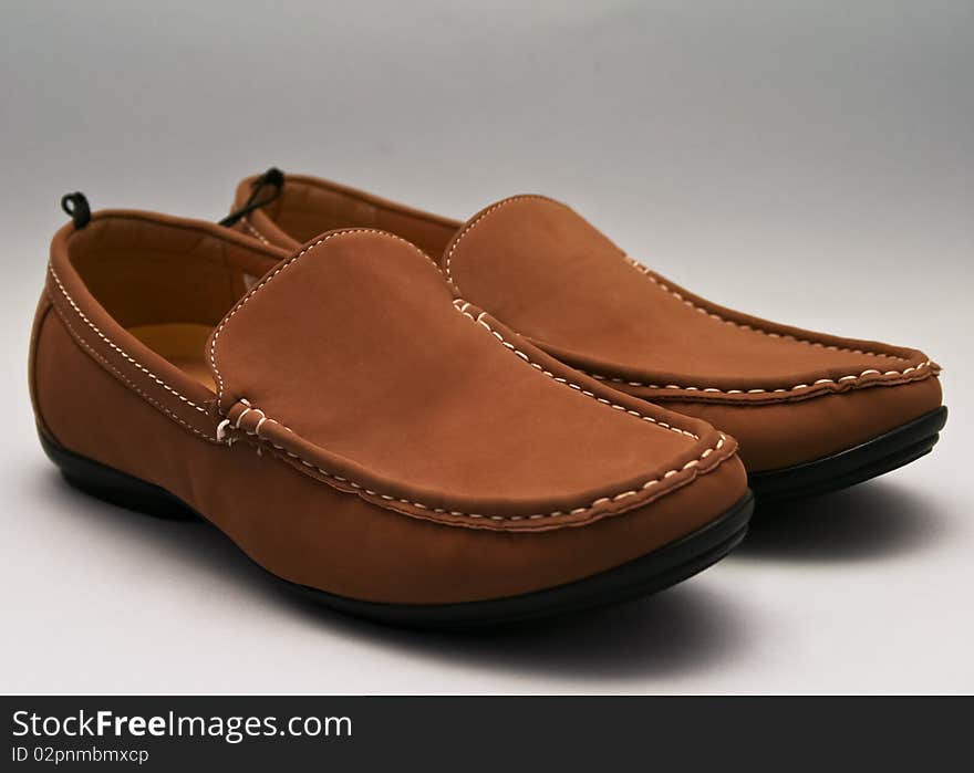 A pair of brown boots, isolated on grey background.