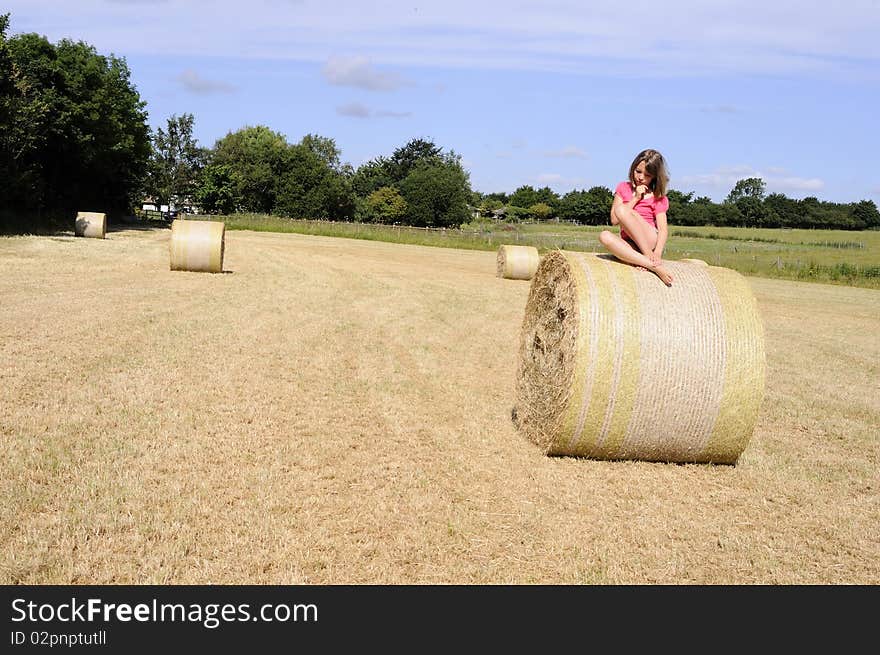 Caucasian teen thinking on hay bales