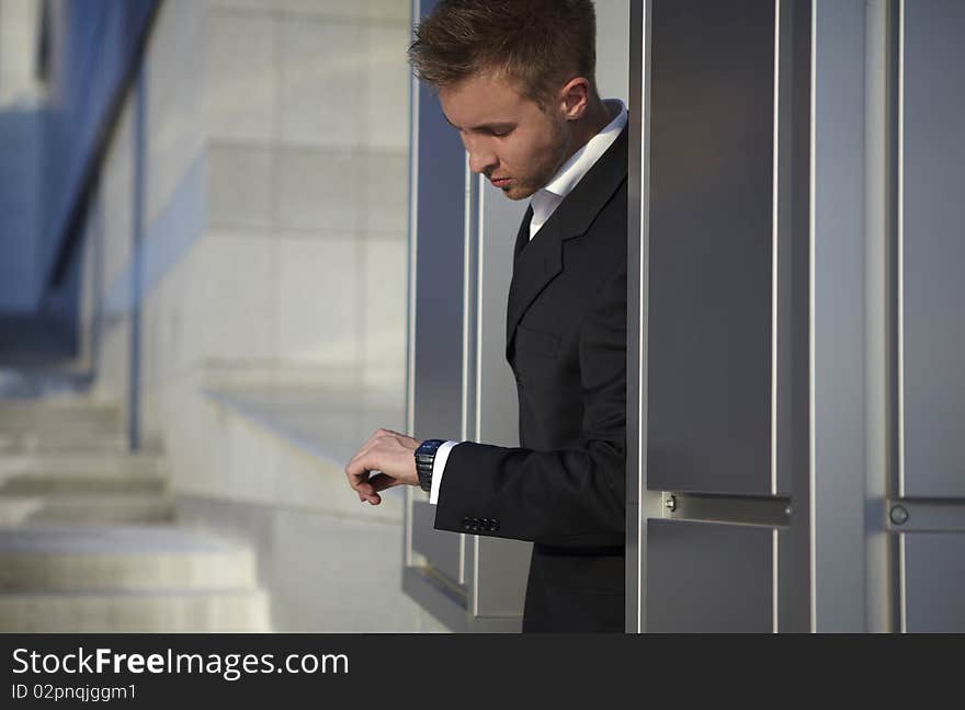 Checking the time. Worried young businessman. Checking the time. Worried young businessman