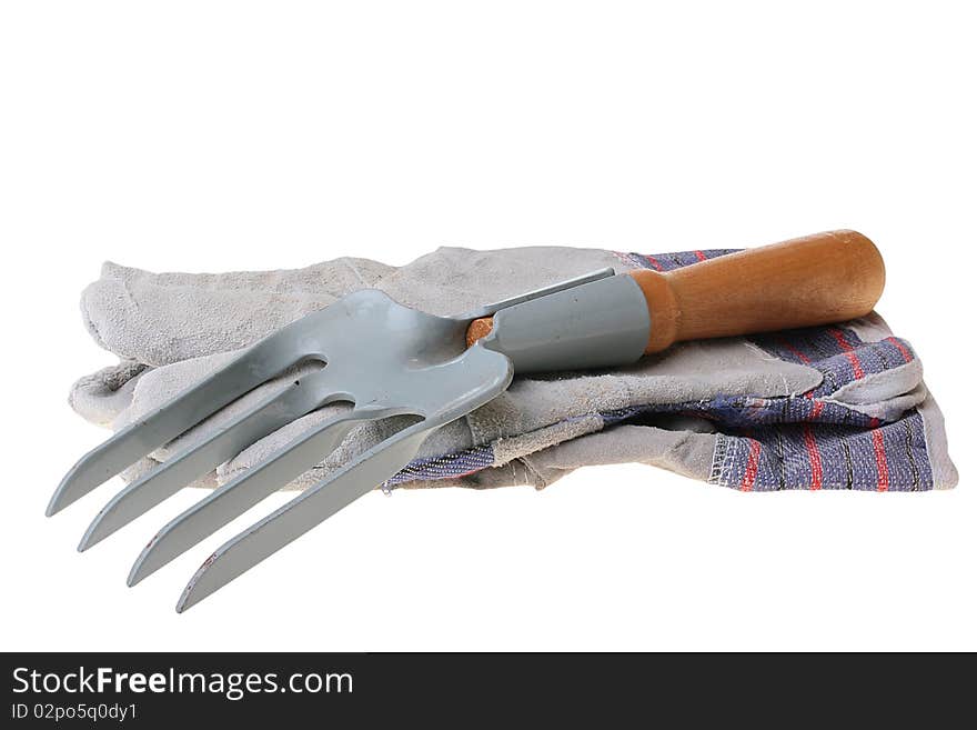 Rake for removal of weeds and a glove for work in a garden.