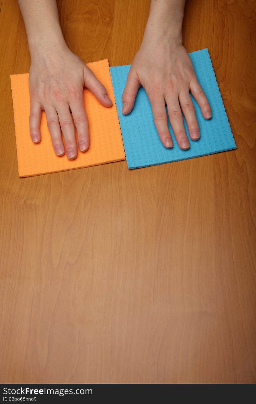 Hand with a cellulose sponge, table