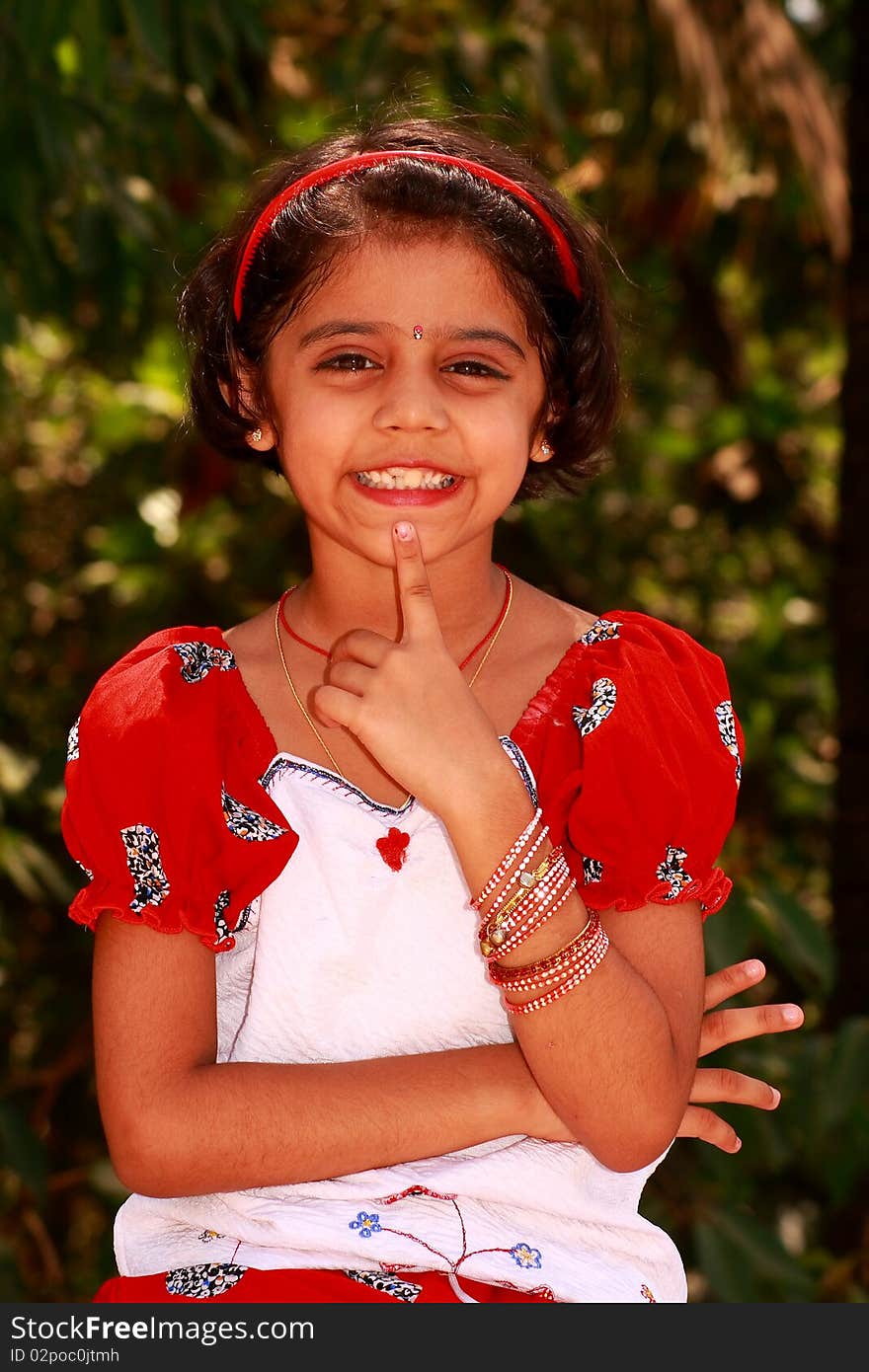 A closeup of a small Indian girl posing with a happy face. A closeup of a small Indian girl posing with a happy face.