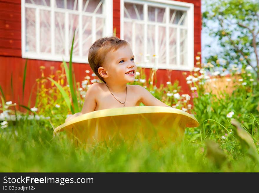 Bathing of the child in a yellow plastic bath