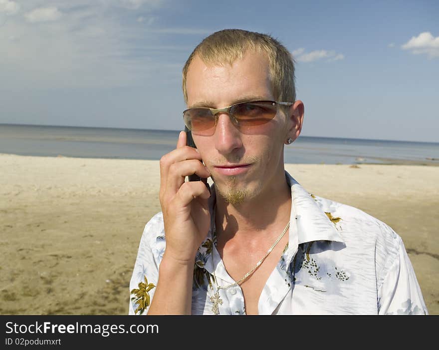 Man talking with mobiles phone on the beach. Man talking with mobiles phone on the beach.