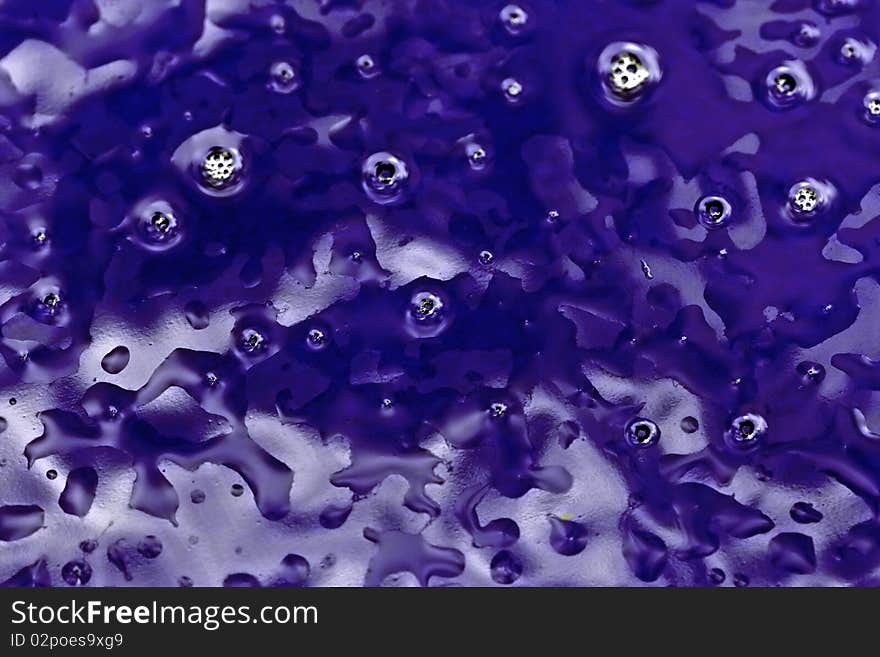 an abstract background of wet blue stained glass with light reflections. an abstract background of wet blue stained glass with light reflections