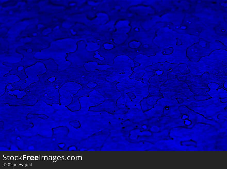 an abstract background of wet, blue, stained glass with light and dark reflections. an abstract background of wet, blue, stained glass with light and dark reflections