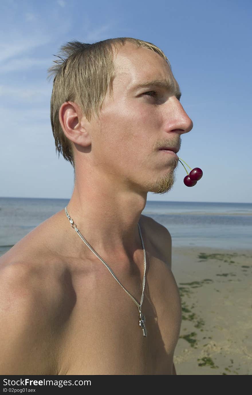 Young man with two cherry in the mouth. Young man with two cherry in the mouth.