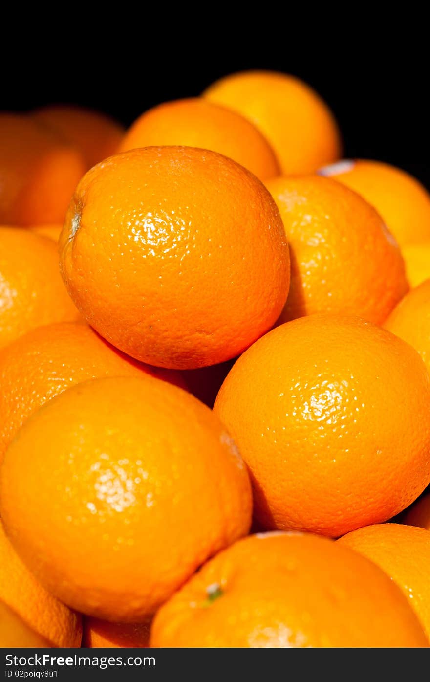 Pile of fresh oranges on a black background.